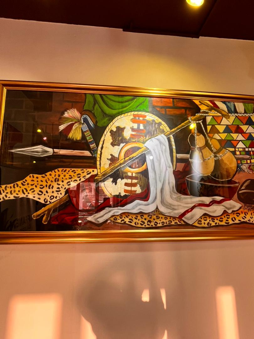 Tableau d'objets traditionnels djiboutiens — bouclier, lance, calebasses et peau de léopard